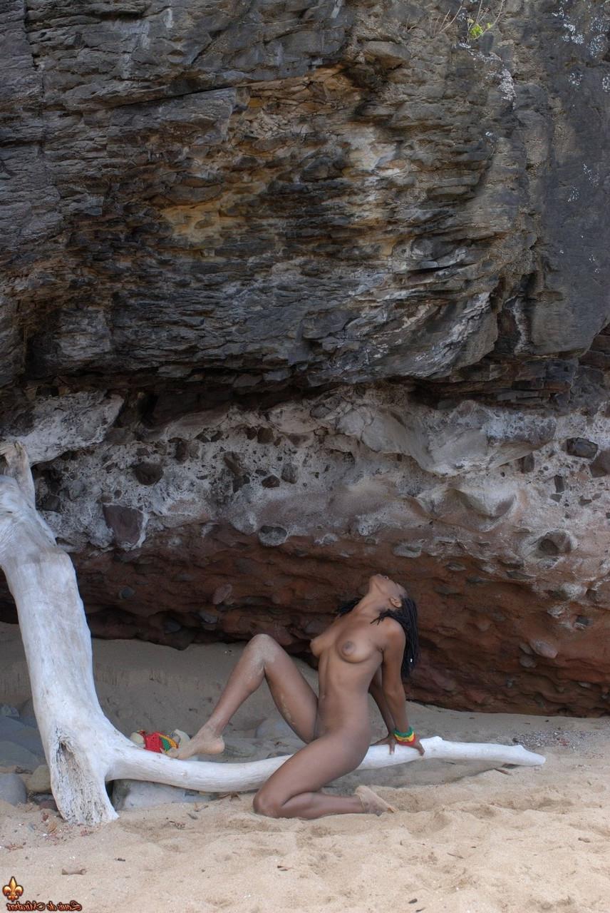 16P A garota negra Diamaa fica completamente nua em madeira flutuante em uma praia
