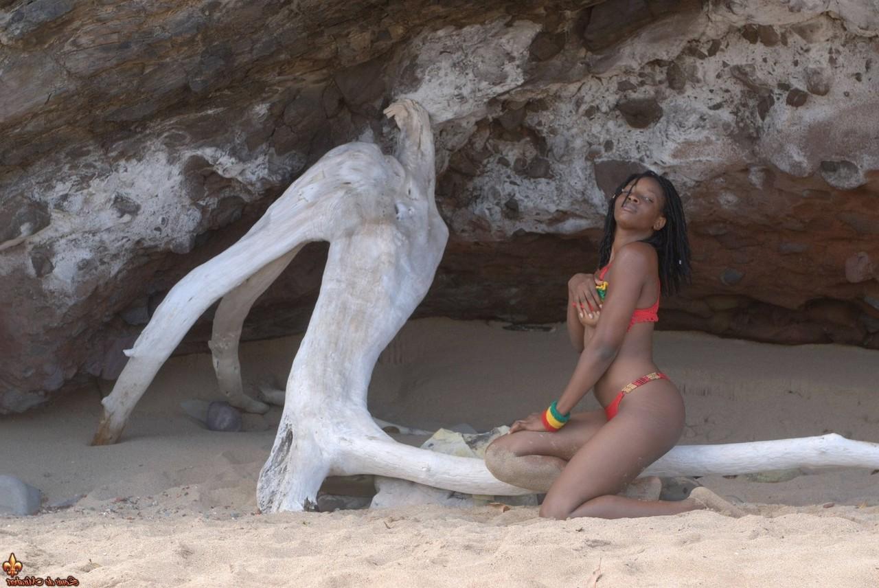 16P A garota negra Diamaa fica completamente nua em madeira flutuante em uma praia