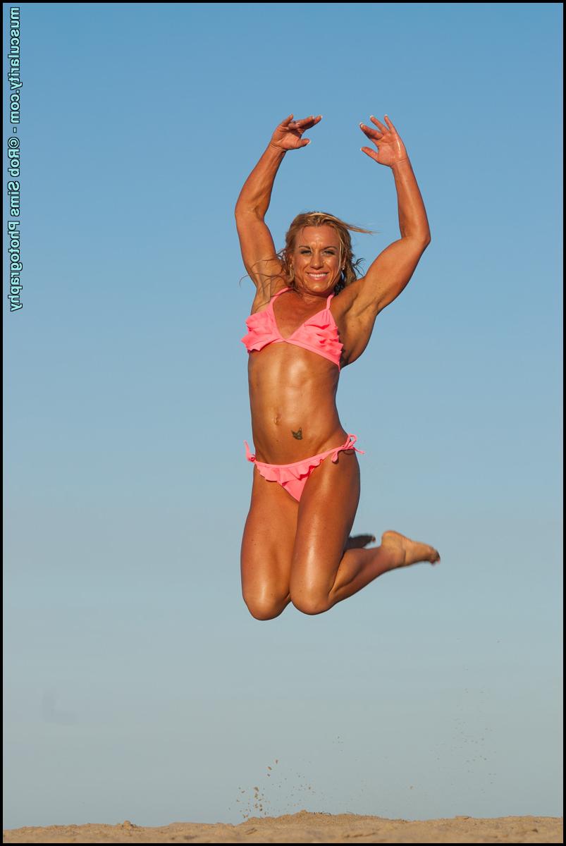15P Blonde fitness model Danielle Delorefice flexes while at the beach