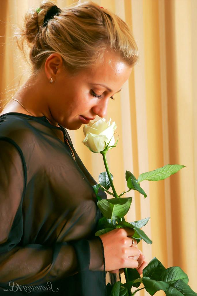 16P La jeune blonde Lory tient une rose à longue tige tout en se mettant nue.