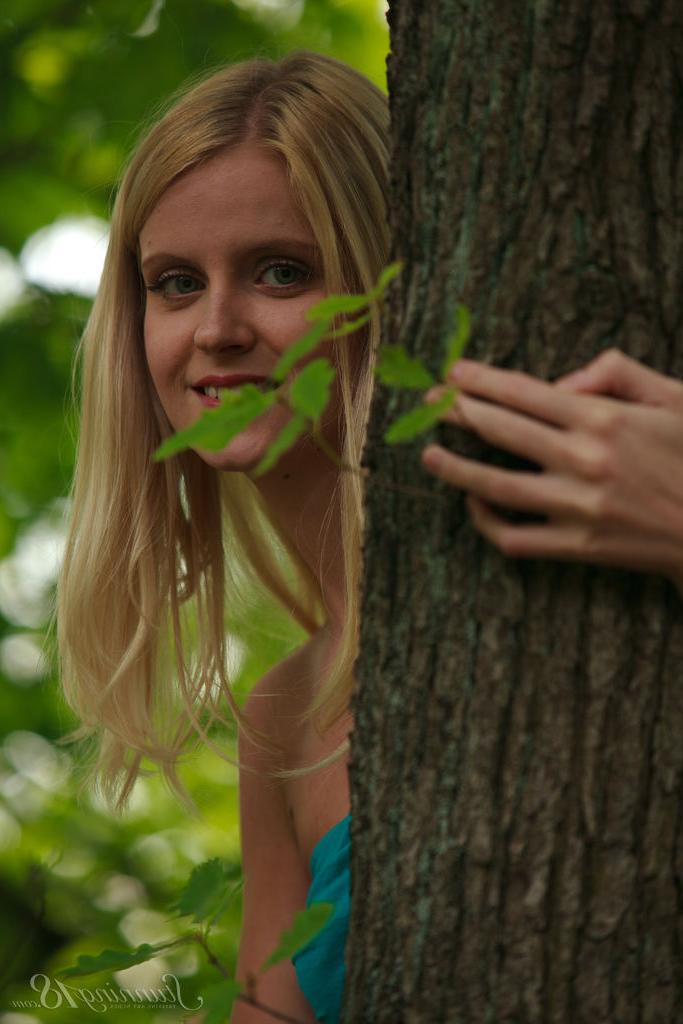16P La jeune blonde naturelle Aneta se met totalement nue sous un arbre.