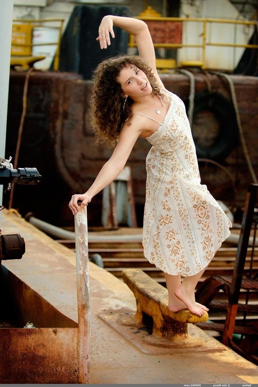 20P Curly haired cutie Sativa shows her firm big tits and hairy pussy on a dock
