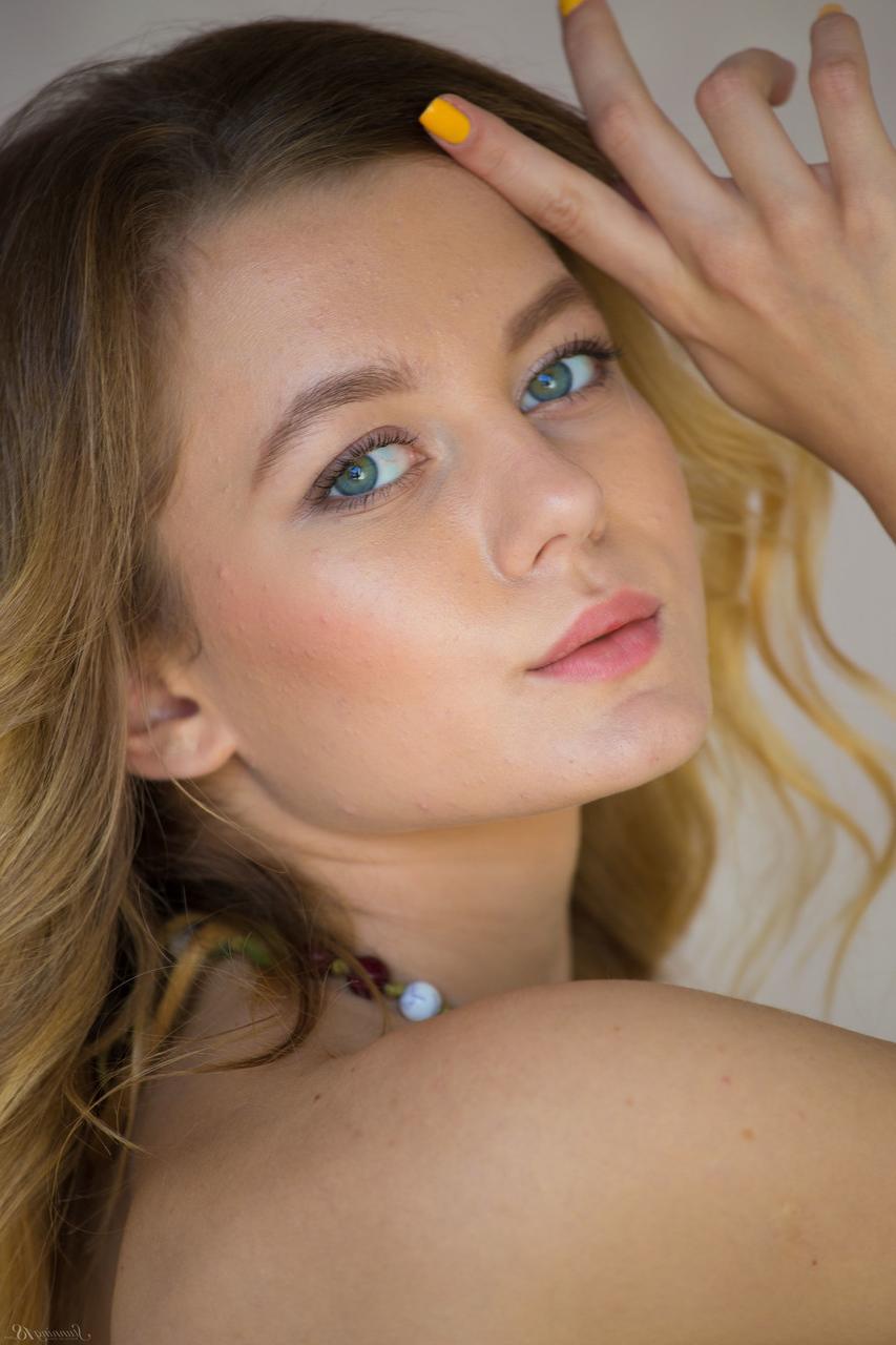 17P La blonde Agnès aux grands yeux bleus regarde de manière érotique pendant qu'elle déshabille son corps mince.