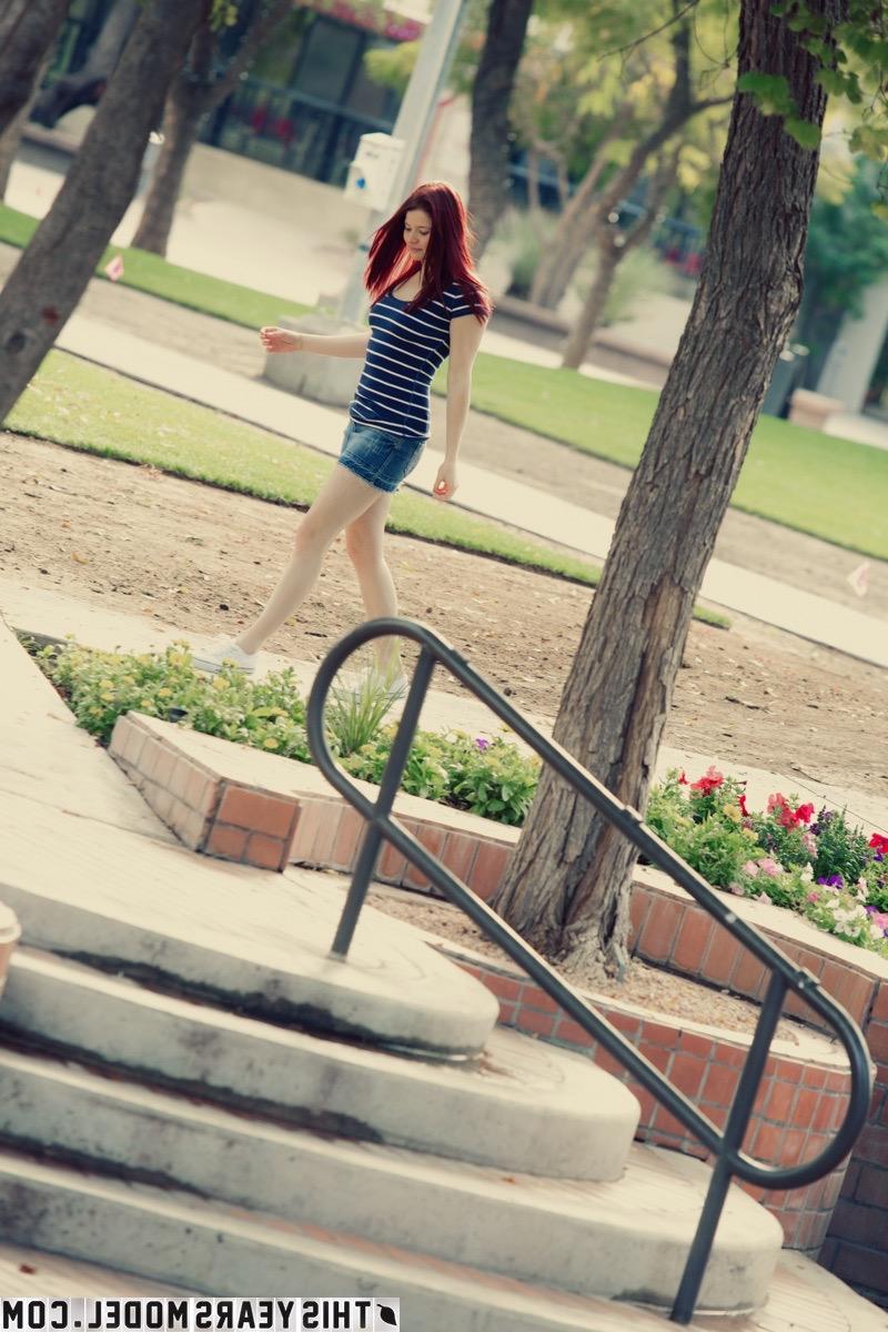 15P Mindy Corin, rousse naturelle, s'expose dans un parc public.
