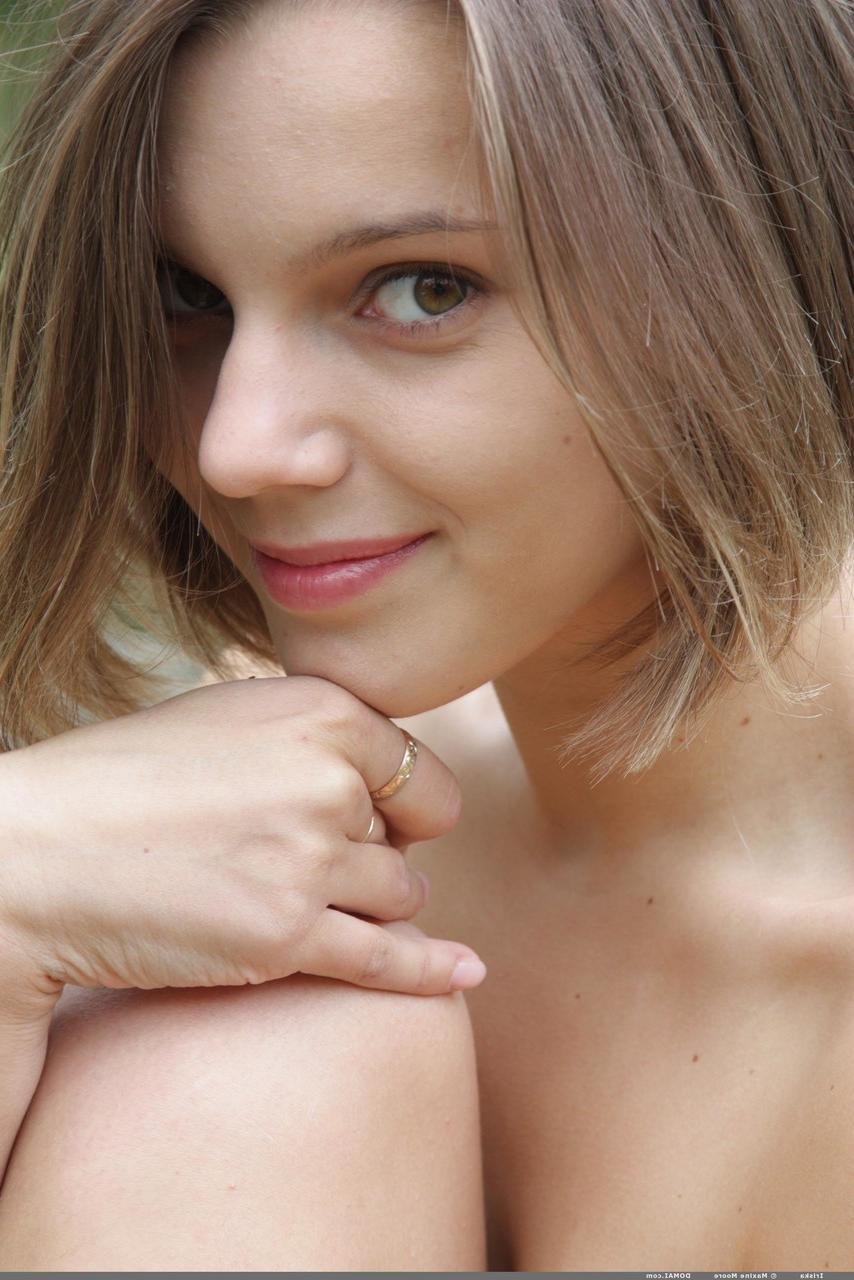 20P Das glamouröse Teenie-Babe Iriska posiert nackt auf einer Holzbank in der Natur