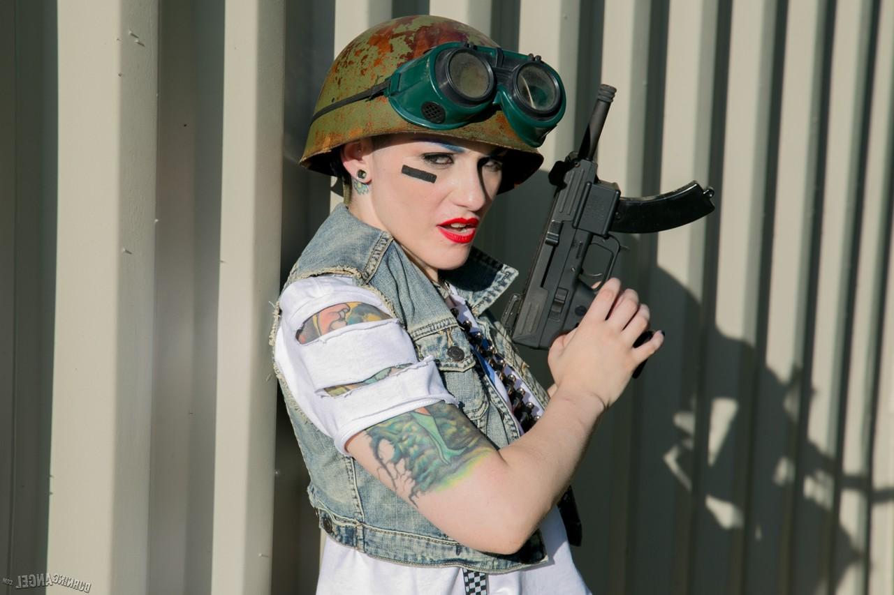 13P Tattooed chick with shaved head in army gear giving man in ape mask a BJ