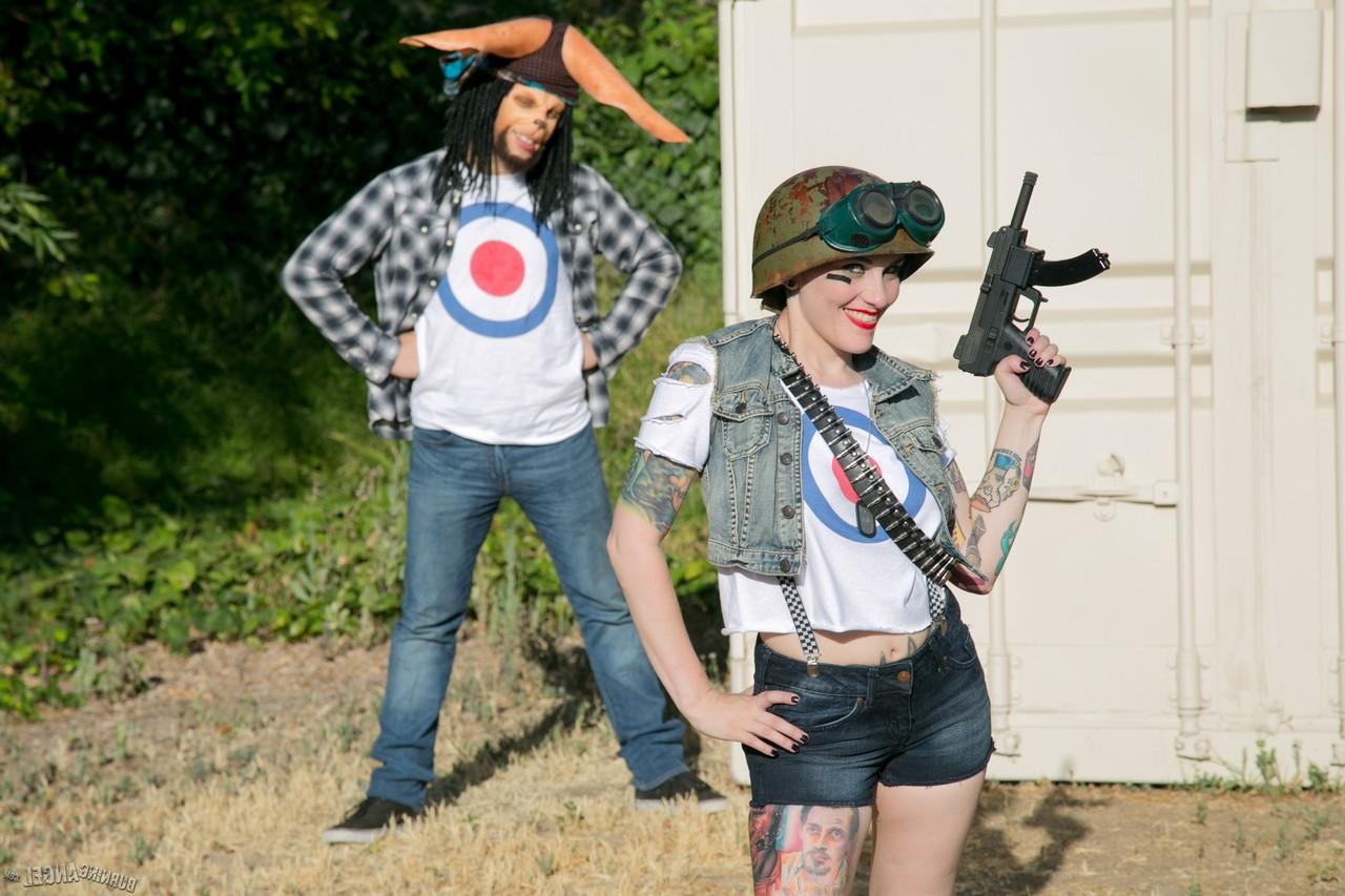 13P Tattooed chick with shaved head in army gear giving man in ape mask a BJ