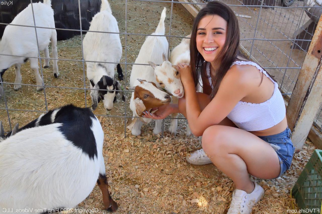 20P A sorridente gata amadora Kylie posa de short jeans e camisa branca no zoológico