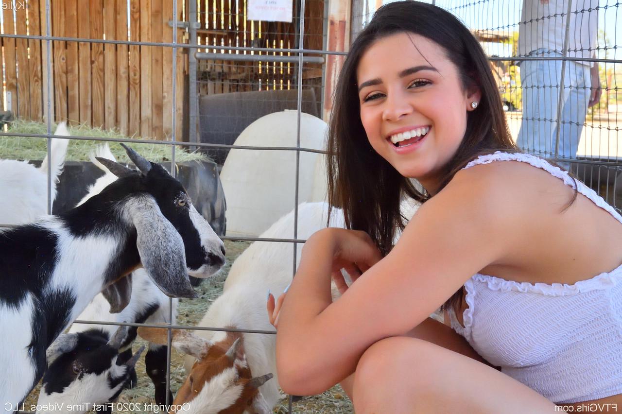 20P A sorridente gata amadora Kylie posa de short jeans e camisa branca no zoológico