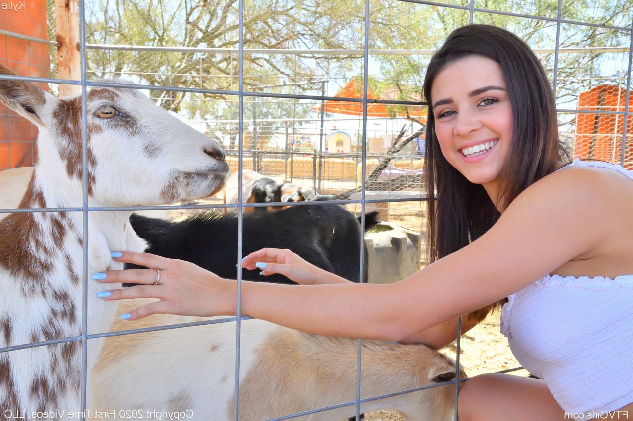 20P A sorridente gata amadora Kylie posa de short jeans e camisa branca no zoológico