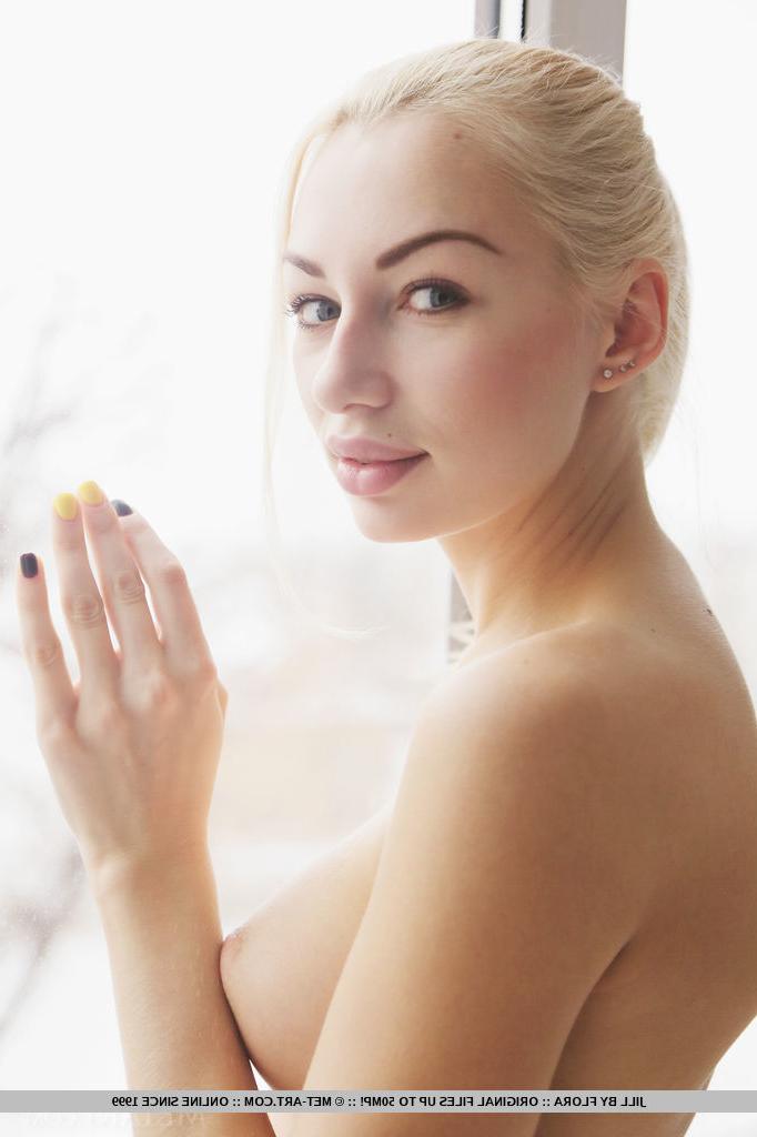18P Jill, jeune blonde platine, tient son cul nu tout en montrant sa fente serrée.