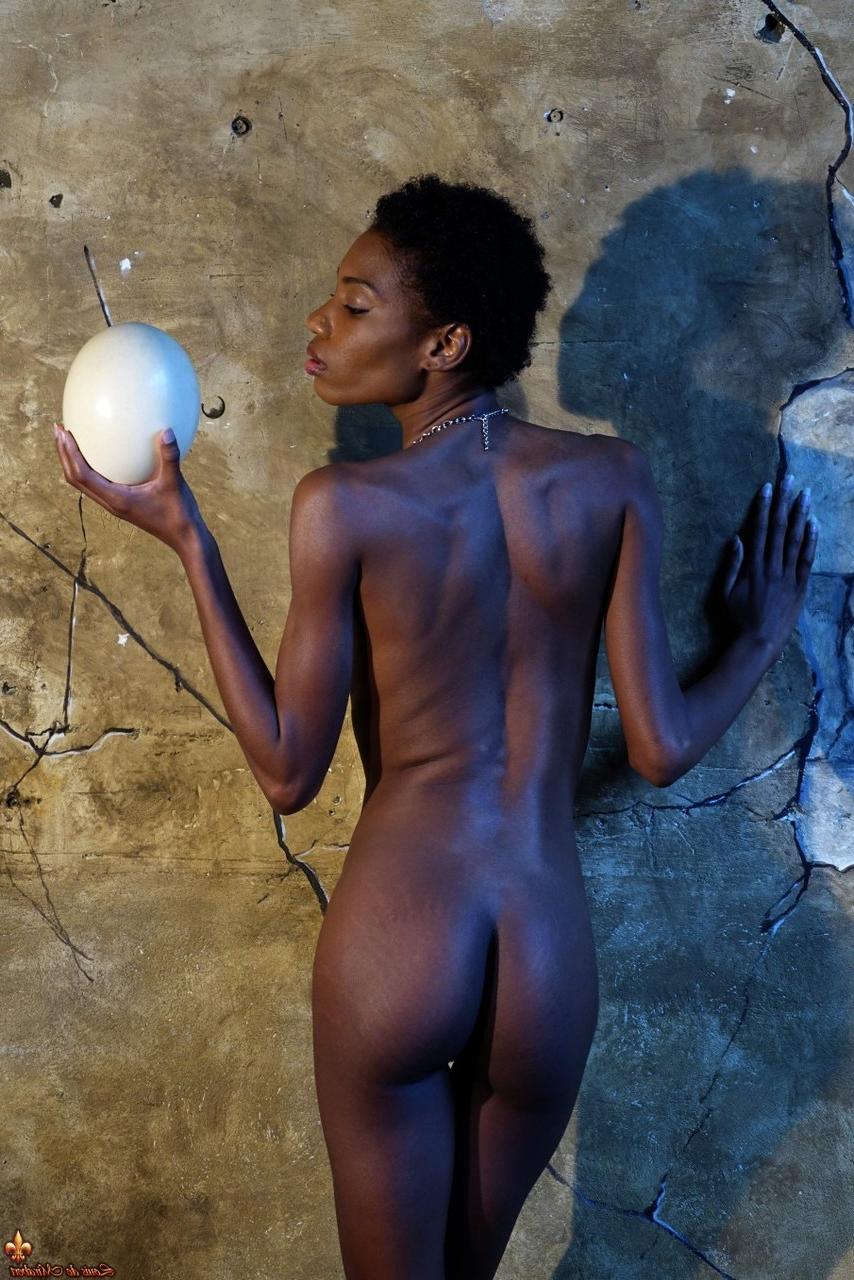 15P Dark skinned girl Jess holds a large egg while modeling butt naked