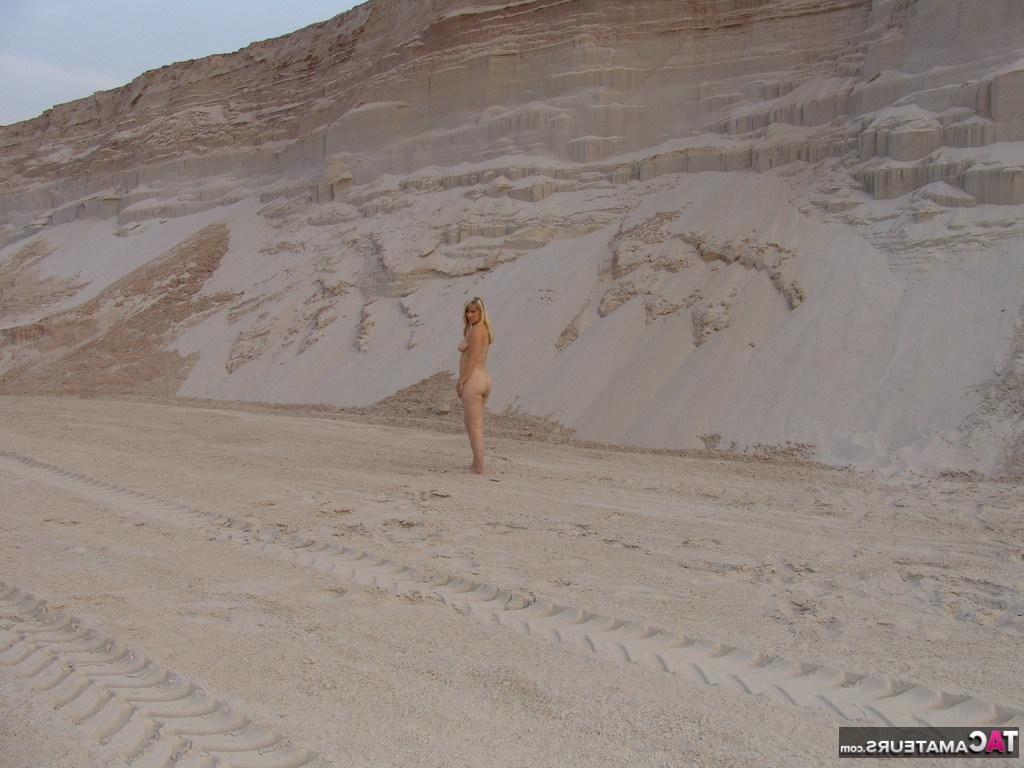 20P La blonde mature Sweet Susi enlève son bikini pour poser nue dans un bac à sable.