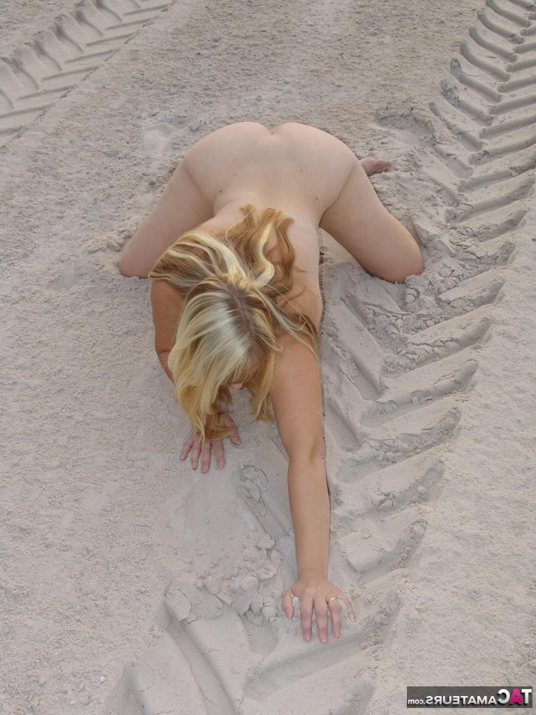 20P La blonde mature Sweet Susi enlève son bikini pour poser nue dans un bac à sable.