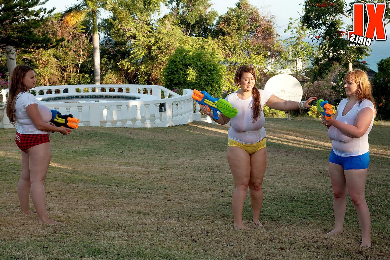 16P Des filles aux gros seins trempent des t-shirts blancs dans une cour avec des pistolets à eau super-soakers.