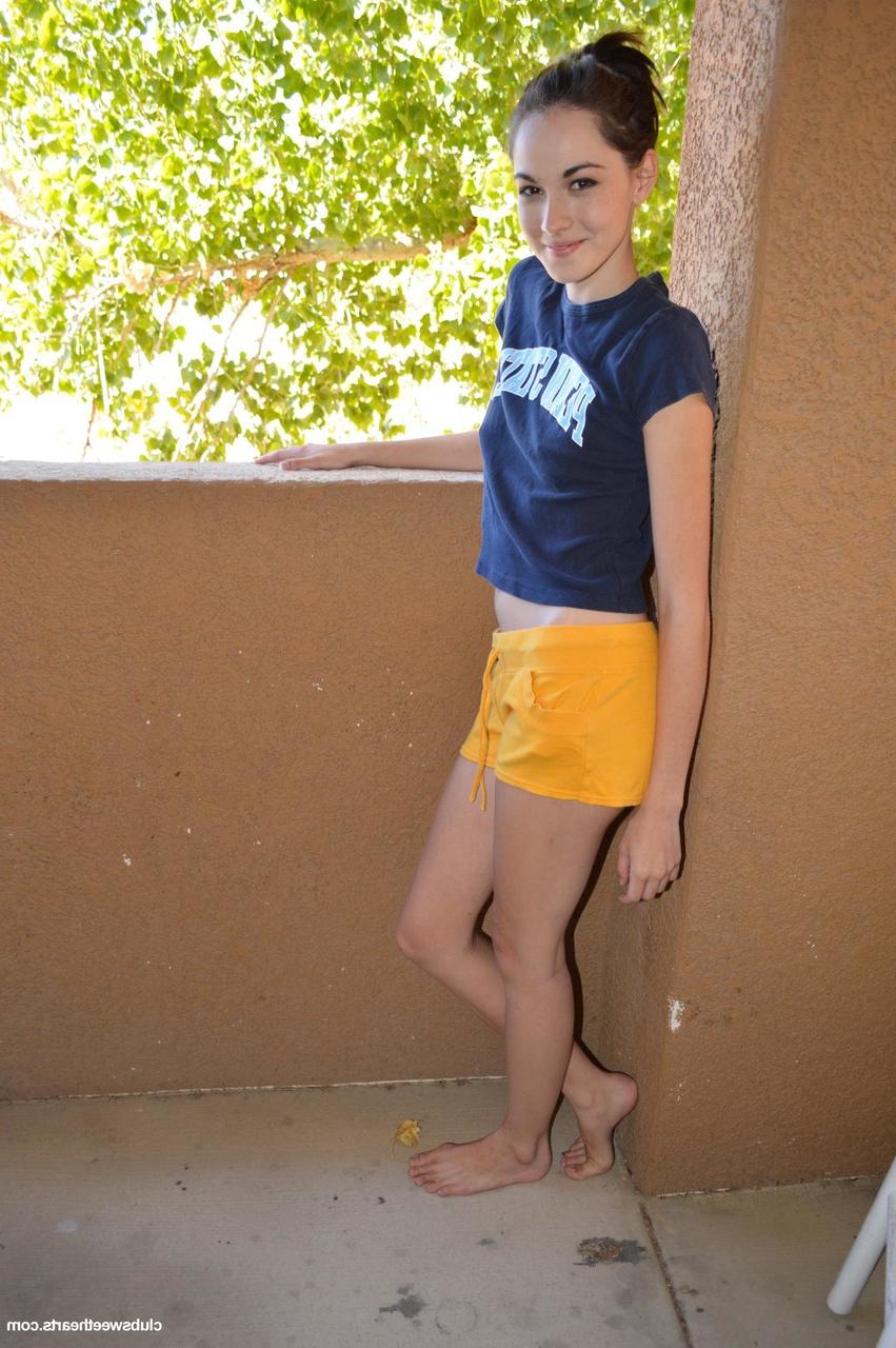 20P La joven delgada emily grey se quita sus sexys shorts amarillos y muestra su culo redondo