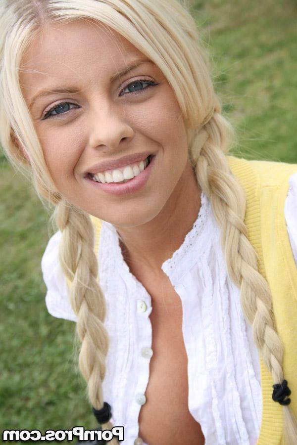16P Adolescente com olhos azuis e seios falsos Britney Amber brinca com seu decote do lado de fora