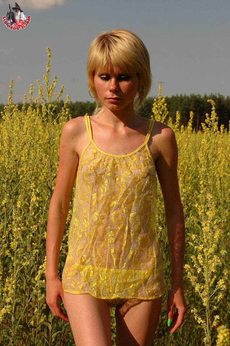 14P Una joven rubia muestra su cuerpo delgado en medio de flores silvestres