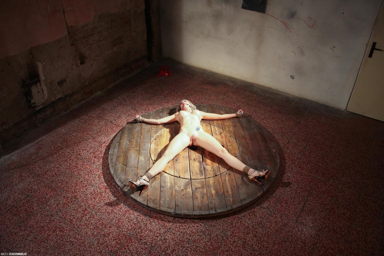 17P Naked Victoria lays like a starfish being tied to the round wooden scene