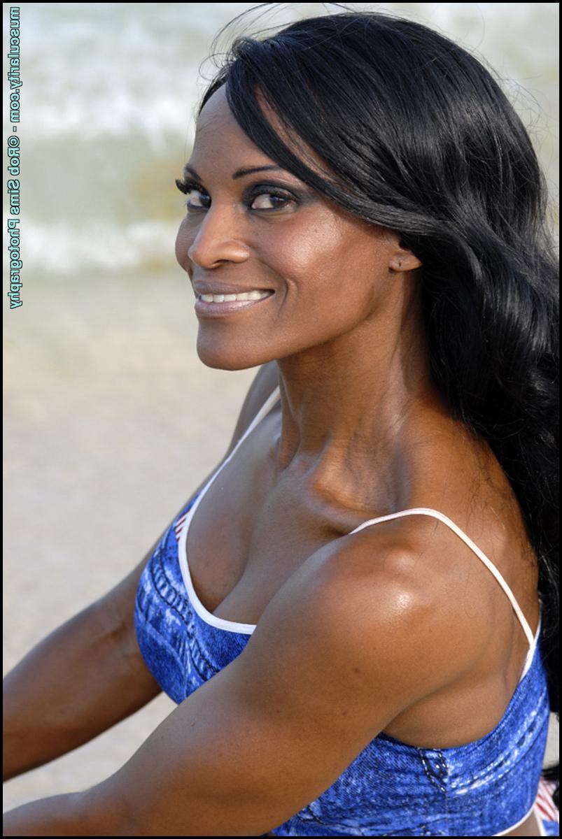 15P La culturista negra Debra Dunn flexiona sus músculos en la playa con un traje vaquero