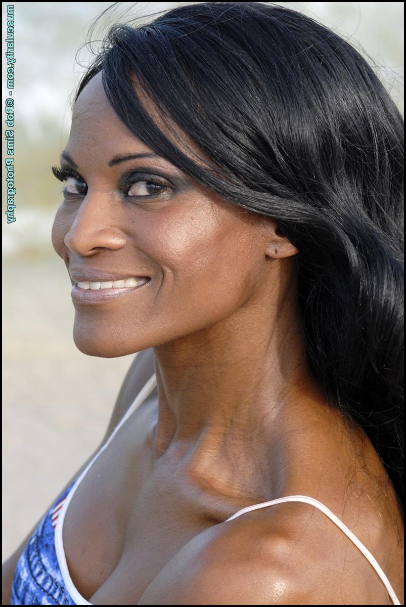 15P La culturista negra Debra Dunn flexiona sus músculos en la playa con un traje vaquero