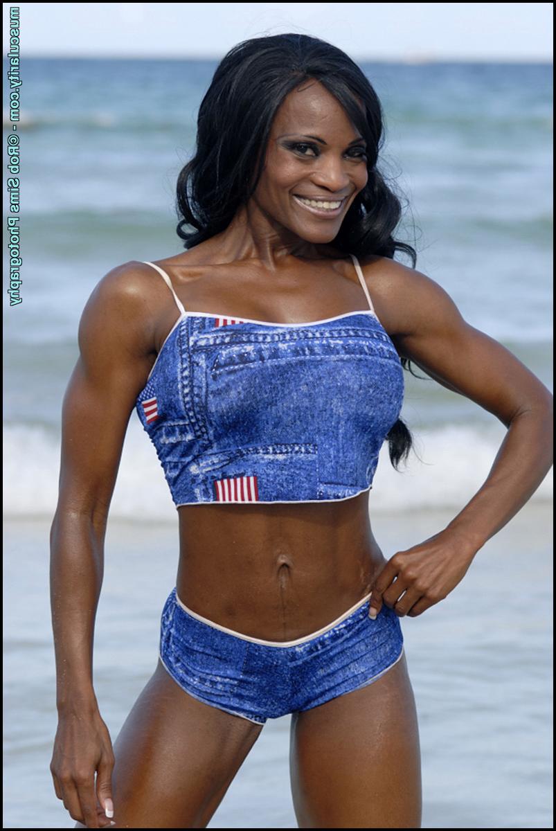 15P La culturista negra Debra Dunn flexiona sus músculos en la playa con un traje vaquero