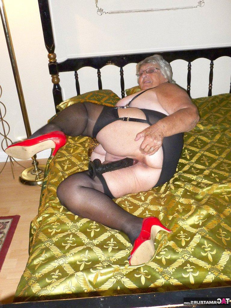 20P La vieja abuela amateur Libby se mete un gran consolador negro en el coño en una cama