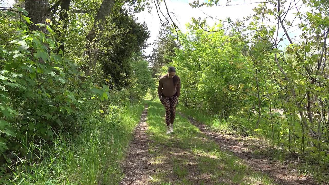 15P Chica blanca con gafas se baja las mallas para orinar en un camino en el bosque