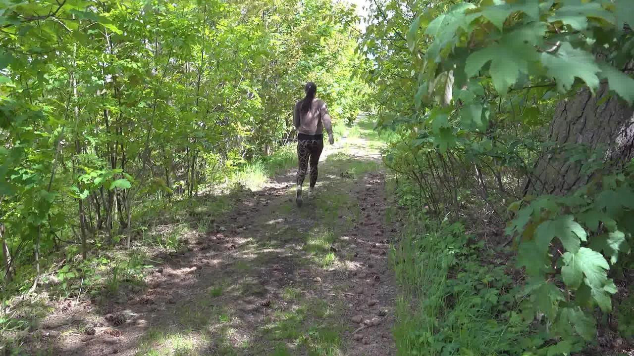 15P Chica blanca con gafas se baja las mallas para orinar en un camino en el bosque