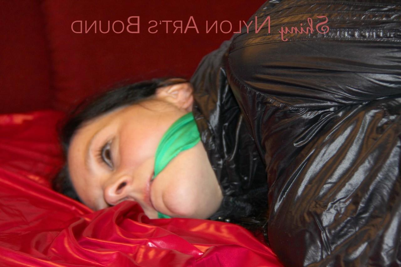 16P Brunette chick is hogtied and cleave gagged in a nylon coat and gym shorts