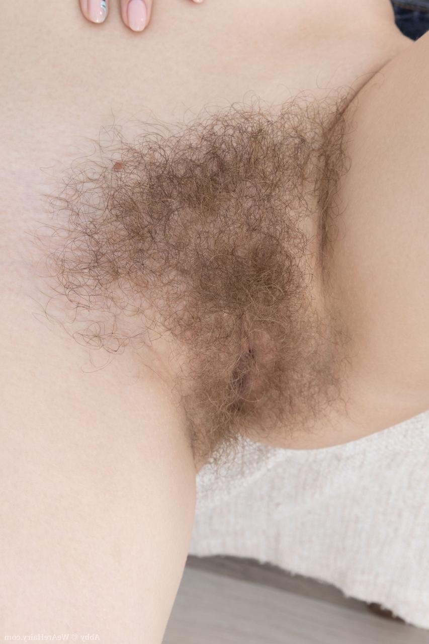 20P Redheaded nerd Abby gets rid of her clothes and exposes her hairy pussy