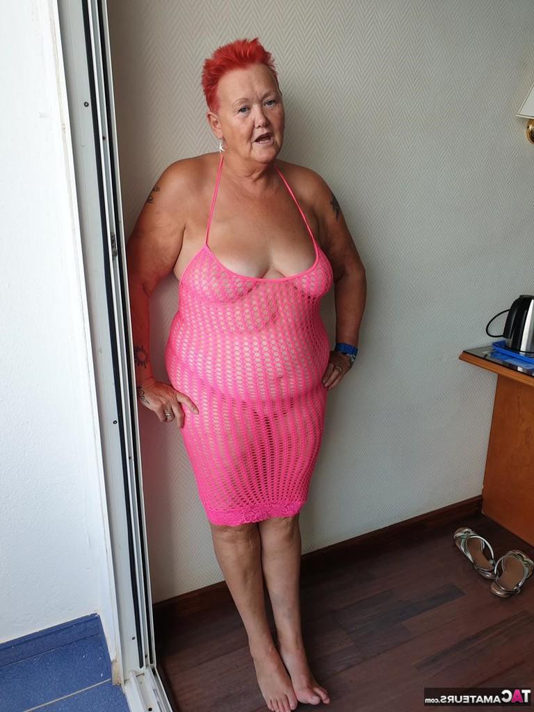 20P Fette Oma mit kurzen roten Haaren spreizt mit dem Finger ihre Muschi auf dem Balkon am Meer