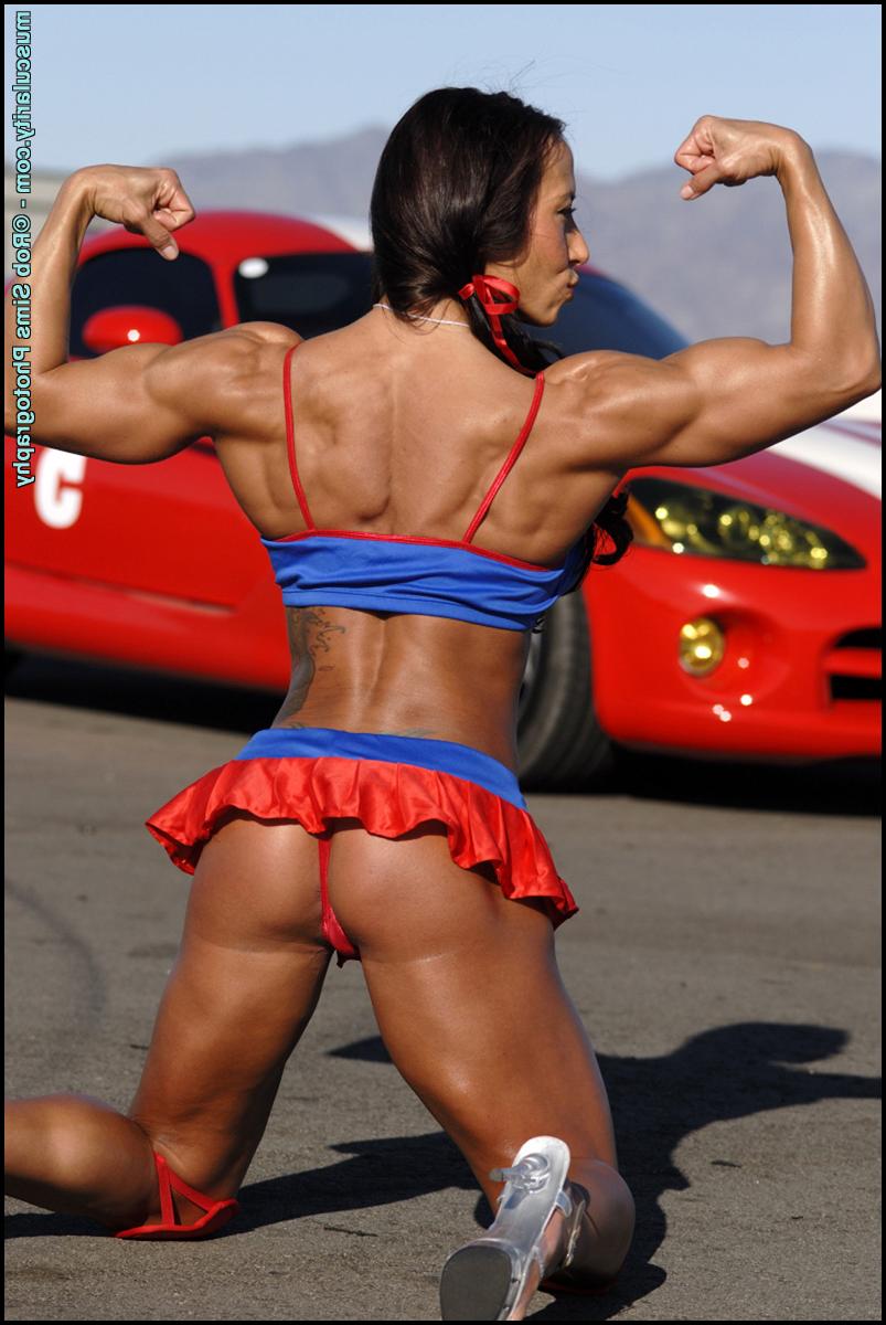 15P Female bodybuilder Patricia Beckman flexes afore a sports car in a SFW shoot