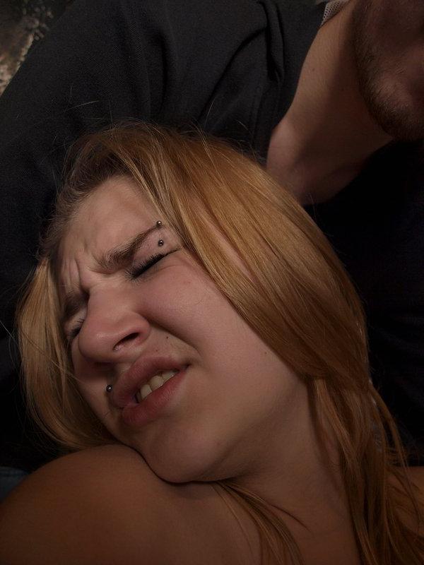 12P Caucasian girl grimaces in pain while being affixed with clothes pegs
