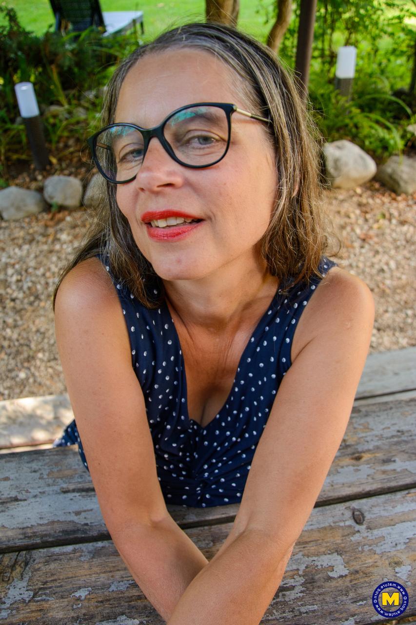 20P Sale GILF à lunettes La plantureuse Tina laisse échapper ses incroyables gros seins et son cul à l'extérieur