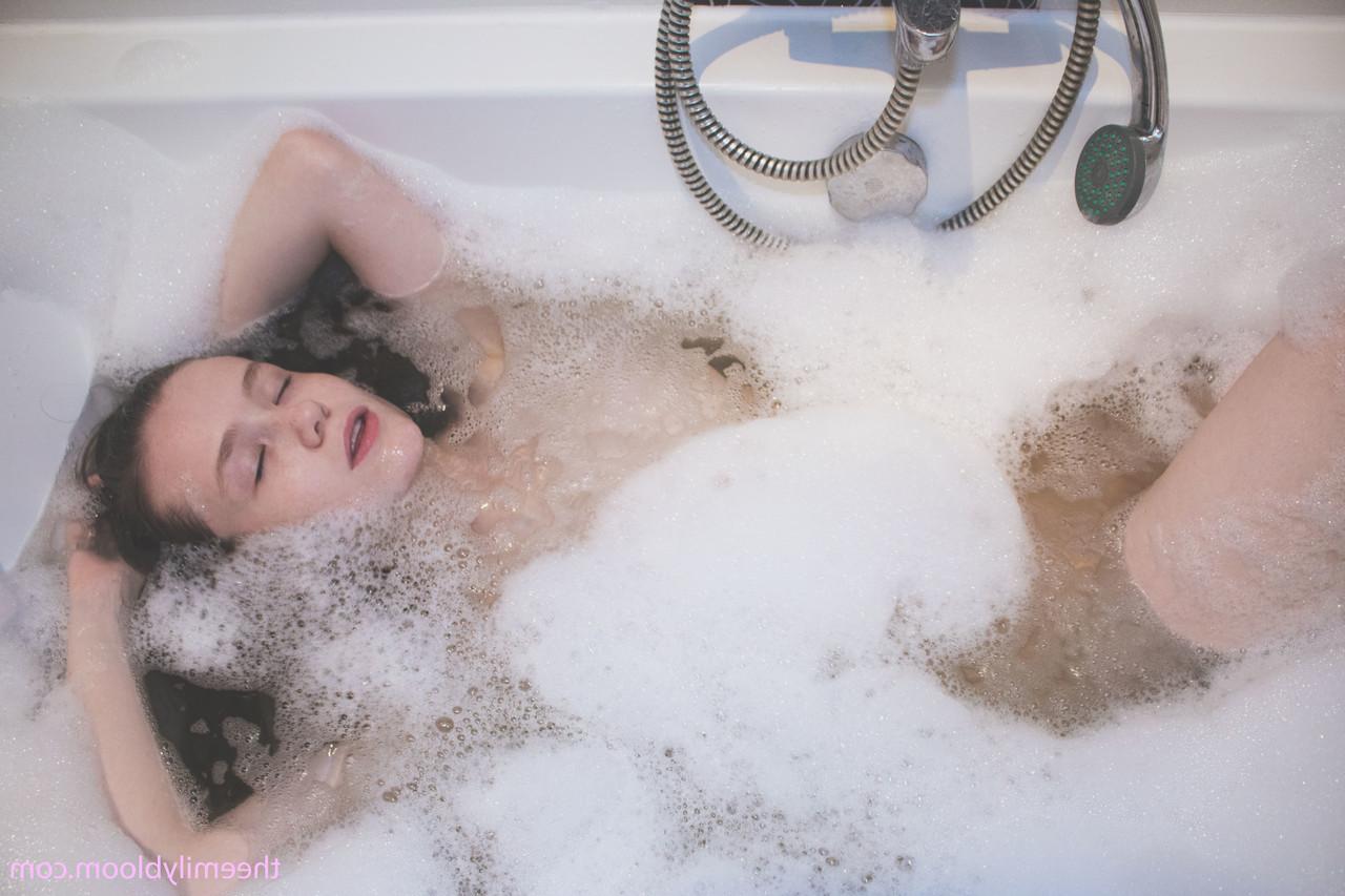 17P Petite mignonne posant dans la salle de bain savonne son jeune corps chaud dans la baignoire
