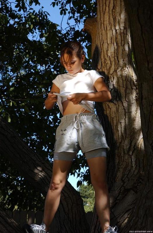 20P Karma, petite jeune, enlève ses vêtements pour poser nue dans un arbre.