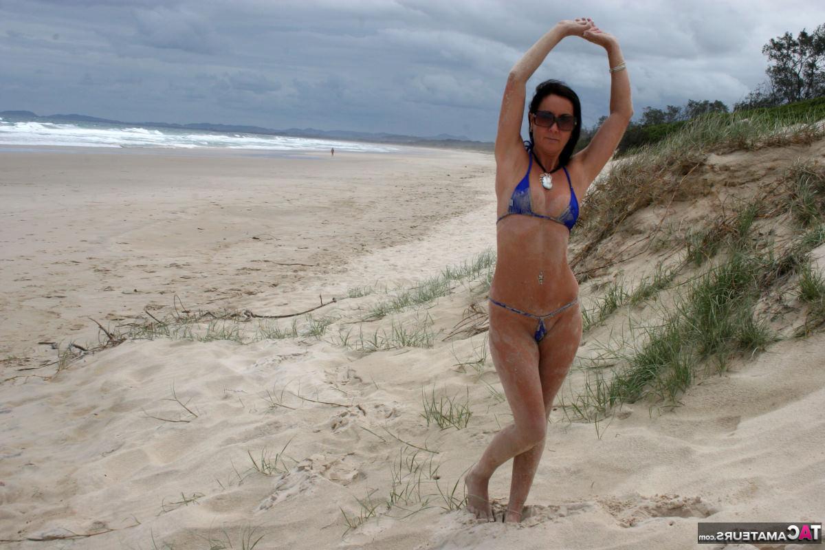 16P La morena roxeanne deambula por una playa de arena en traje de baño revelador