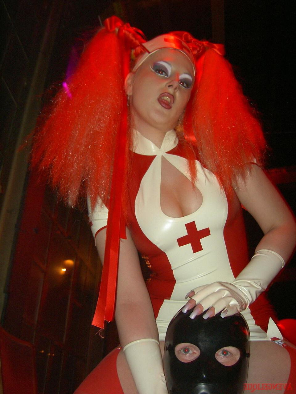 16P Una mujer caucásica domina a un hombre sumiso mientras usa ropa fetichista de látex.