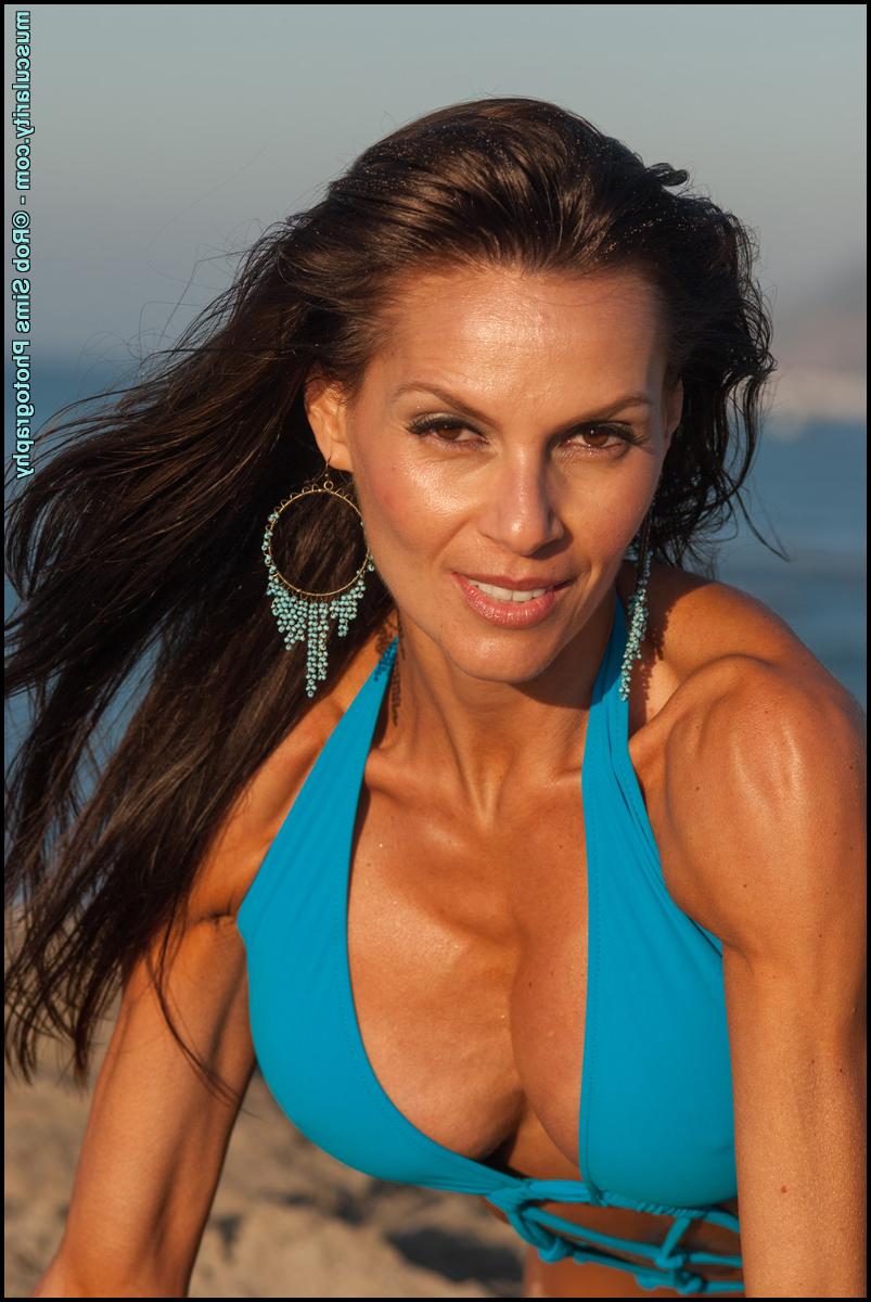 15P Bodybuilder Lupita Moreno models on a beach in her swimwear