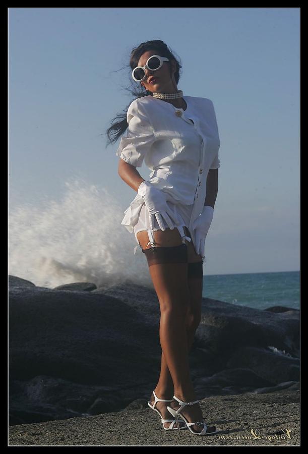 15P Dark haired MILF frees her tits from a girdle at the ocean in retro nylons