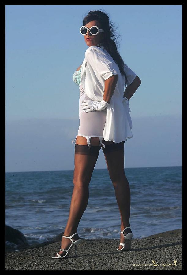 15P Dark haired MILF frees her tits from a girdle at the ocean in retro nylons