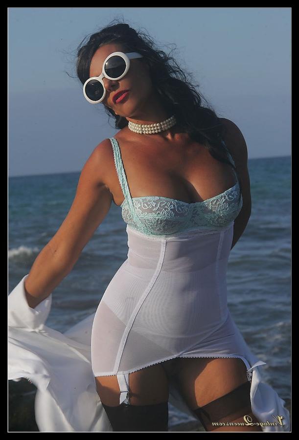 15P Dark haired MILF frees her tits from a girdle at the ocean in retro nylons