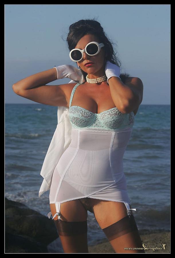 15P Dark haired MILF frees her tits from a girdle at the ocean in retro nylons