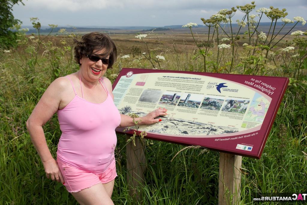 20P La madura BBW Speedy Bee se desnuda en un campo mientras visita un sitio turístico