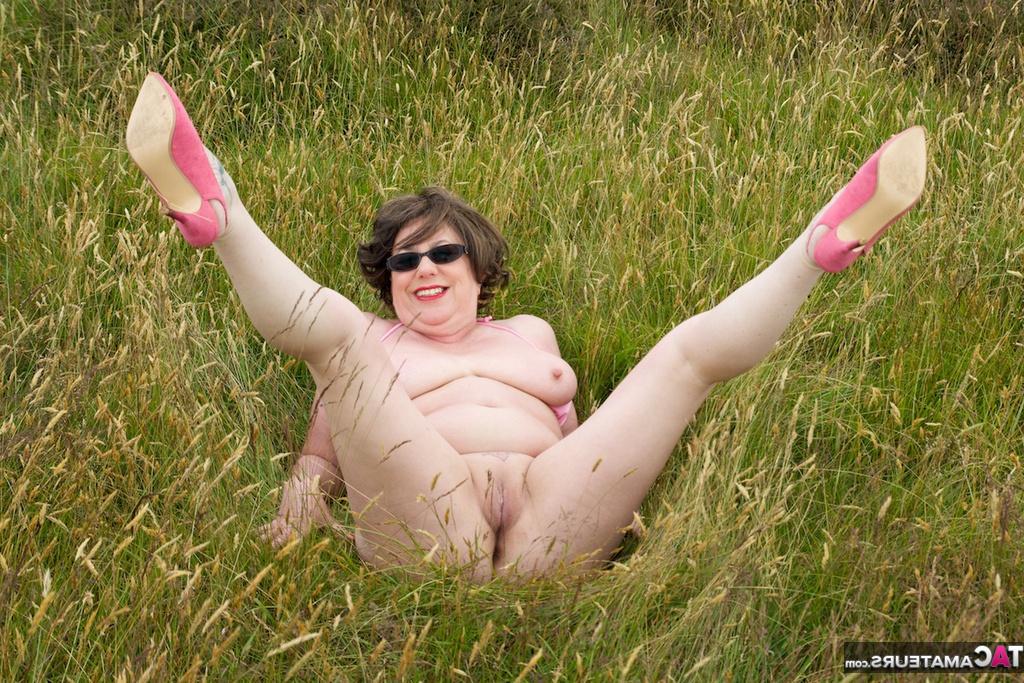 20P La madura BBW Speedy Bee se desnuda en un campo mientras visita un sitio turístico