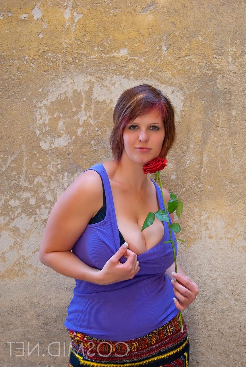 16P Amador BBW Nika segura uma rosa vermelha enquanto mostra amplo decote em um sutiã