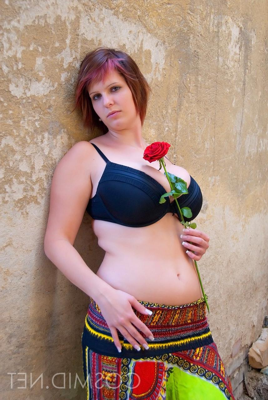 16P Amador BBW Nika segura uma rosa vermelha enquanto mostra amplo decote em um sutiã