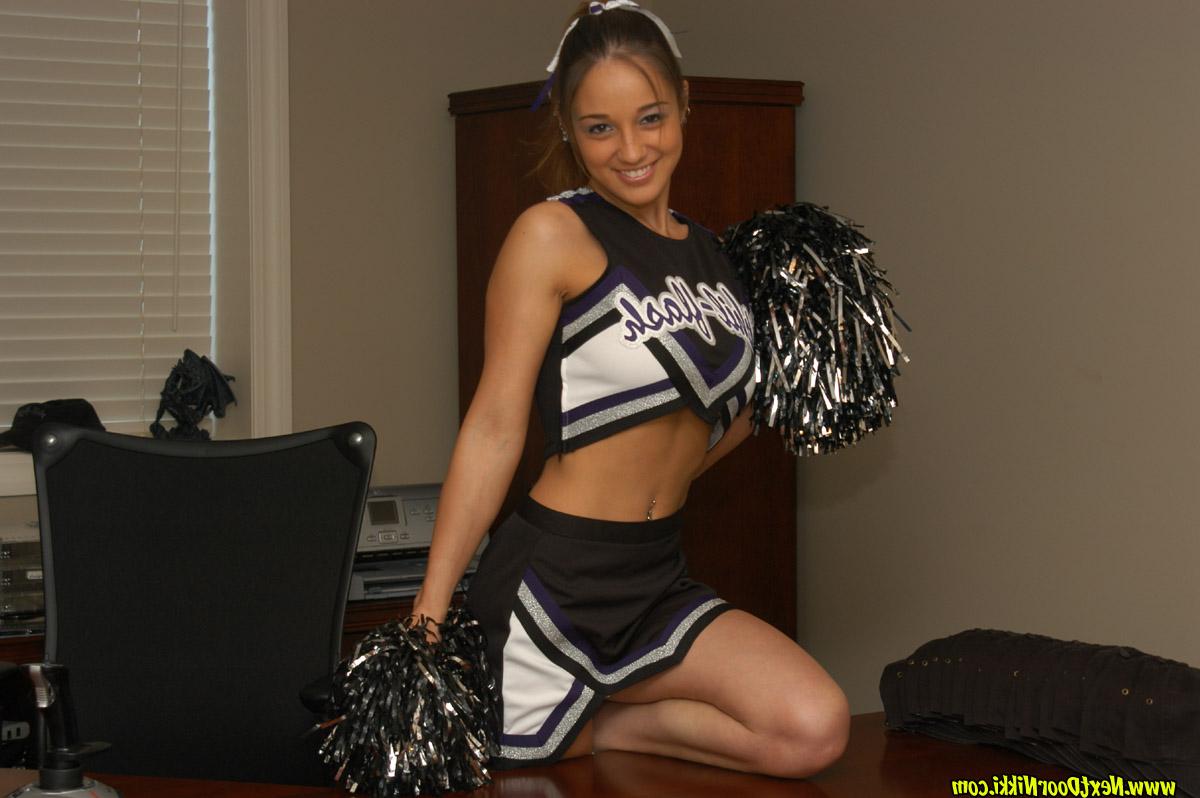 12P Brunette cheerleader Nikki Sims takes off her uniform top in a teasing manner