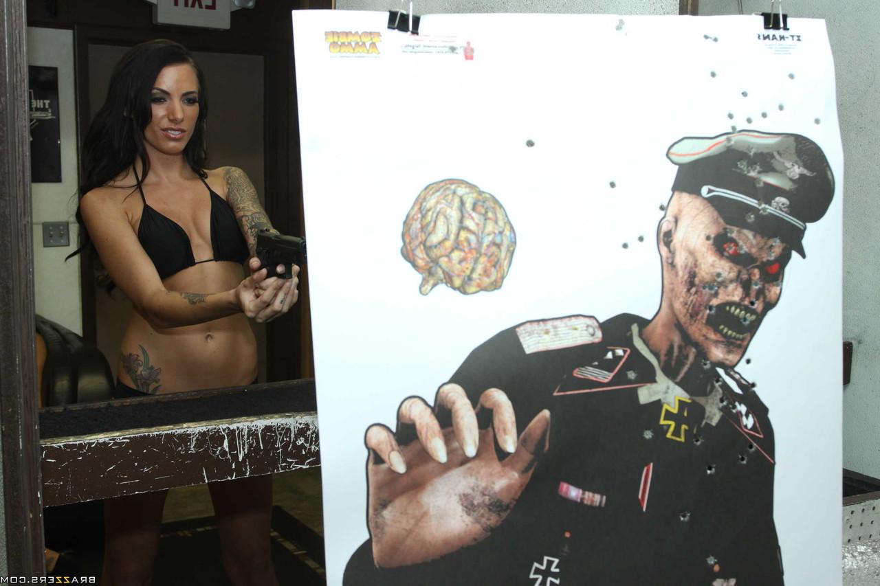 17P Tattooed brunette empties a few rounds at the shooting range in a bikini